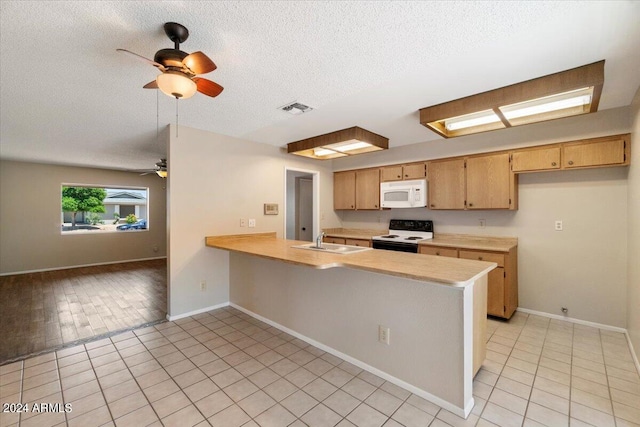 kitchen with sink, kitchen peninsula, a textured ceiling, white appliances, and light tile patterned floors