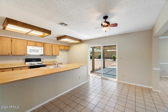 kitchen featuring white appliances, sink, ceiling fan, light tile patterned flooring, and kitchen peninsula