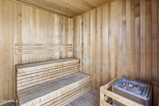 view of sauna featuring wood ceiling, hardwood / wood-style flooring, and wooden walls