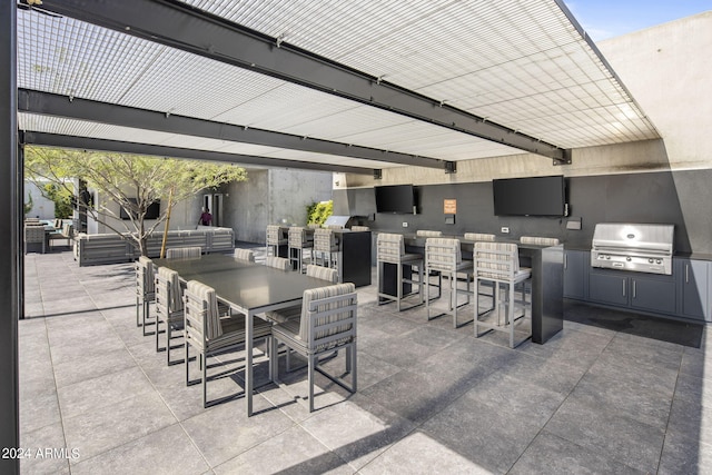 view of patio with area for grilling, an outdoor bar, and exterior kitchen