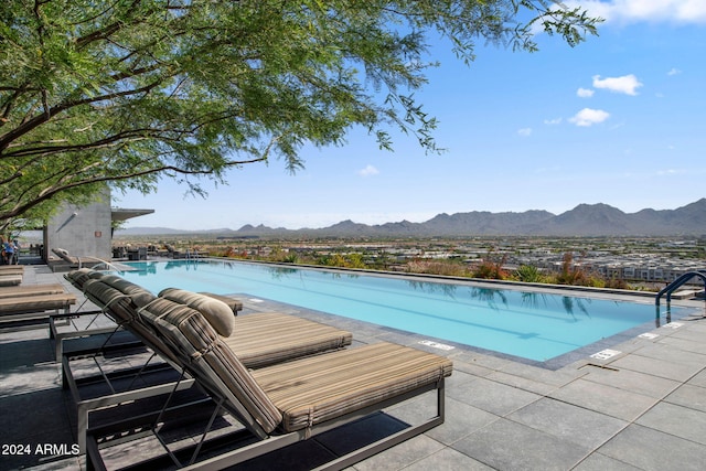 view of pool featuring a mountain view and a patio area