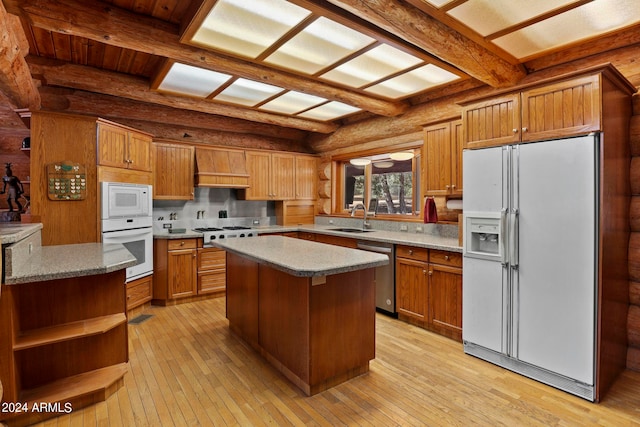 kitchen with light hardwood / wood-style floors, beamed ceiling, sink, a kitchen island, and white appliances