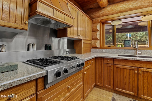 kitchen with custom exhaust hood, sink, stainless steel gas cooktop, wooden ceiling, and light hardwood / wood-style floors