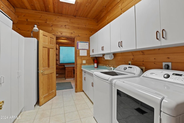 laundry area with light tile patterned floors, wooden walls, washer and clothes dryer, cabinets, and wooden ceiling