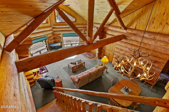 living room featuring log walls, lofted ceiling with beams, wooden ceiling, hardwood / wood-style flooring, and a notable chandelier