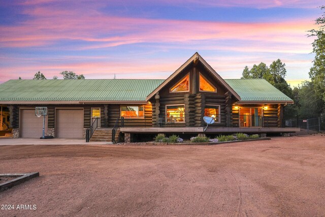 703 N Chaparral Pines Dr, Payson, AZ 85541 - log cabin with metal roof, log siding, driveway, covered porch, and a garage