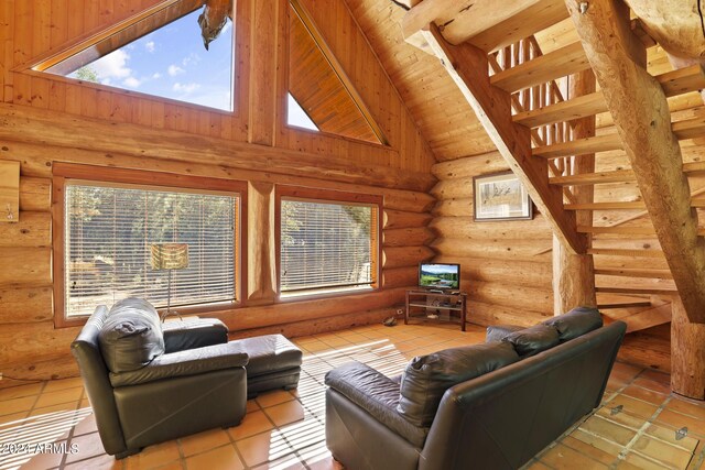 tiled living room with high vaulted ceiling, a wealth of natural light, rustic walls, and beamed ceiling