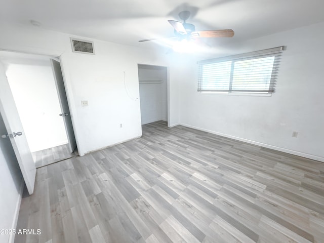 unfurnished bedroom featuring ceiling fan, light hardwood / wood-style floors, and a closet