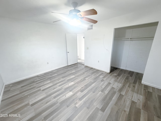 unfurnished bedroom featuring ceiling fan, light hardwood / wood-style floors, and a closet