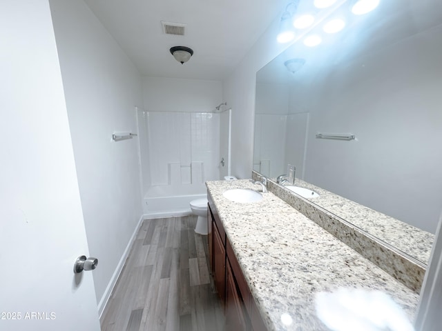 full bathroom featuring toilet, vanity, wood-type flooring, and shower / washtub combination