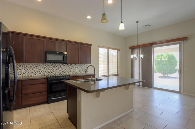 kitchen with a wealth of natural light, decorative backsplash, black appliances, and sink