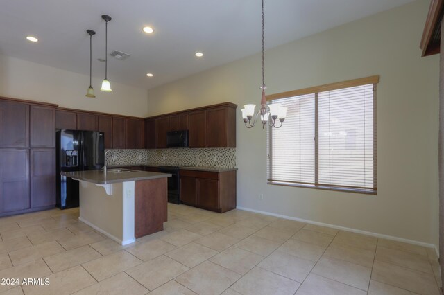 kitchen with decorative backsplash, black appliances, a kitchen island with sink, pendant lighting, and light tile patterned flooring