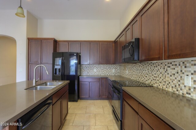 kitchen with tasteful backsplash, sink, black appliances, pendant lighting, and light tile patterned floors