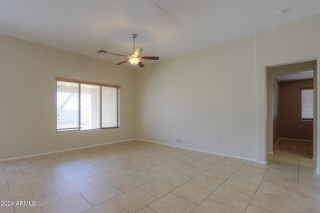 tiled empty room featuring ceiling fan