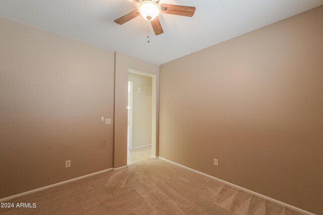 carpeted empty room featuring ceiling fan