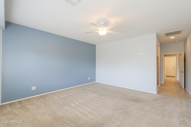 spare room with ceiling fan and light carpet