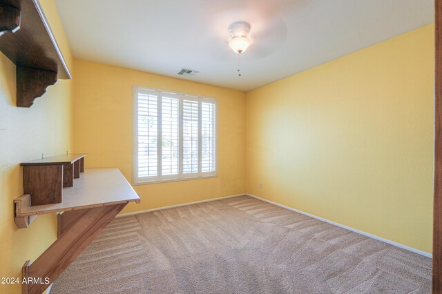 empty room featuring carpet floors and ceiling fan