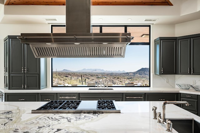 kitchen with stainless steel gas cooktop, visible vents, a mountain view, and extractor fan