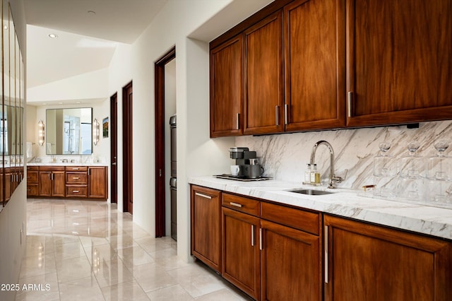 bar with lofted ceiling, backsplash, and a sink