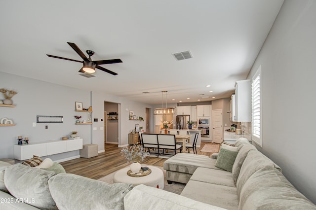 living room featuring light wood-type flooring and ceiling fan