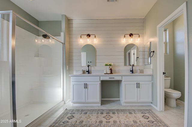 bathroom featuring toilet, a shower with door, vanity, and tile patterned floors