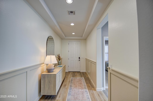 entryway featuring a tray ceiling and light hardwood / wood-style flooring