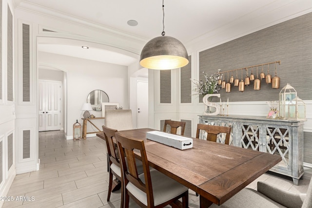 dining area with ornamental molding and indoor bar