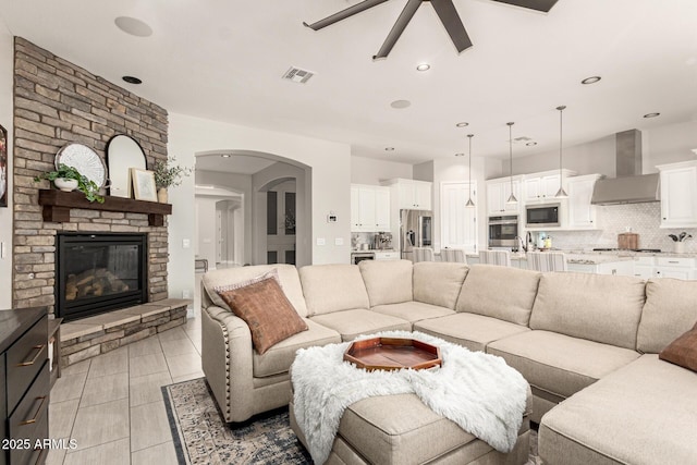 living room with ceiling fan and a large fireplace