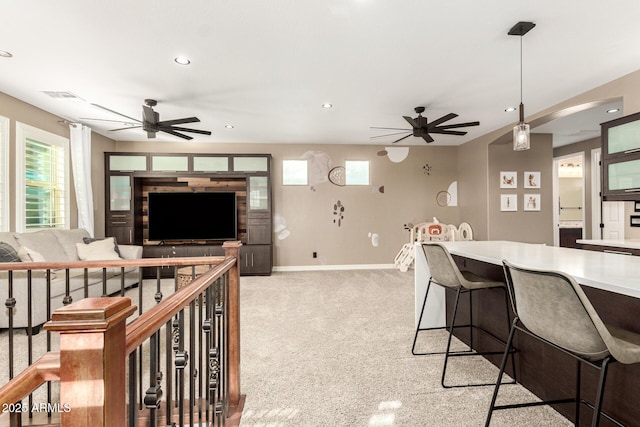 carpeted living room with ceiling fan