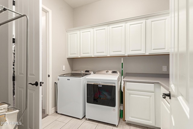 laundry room with cabinets and washing machine and clothes dryer