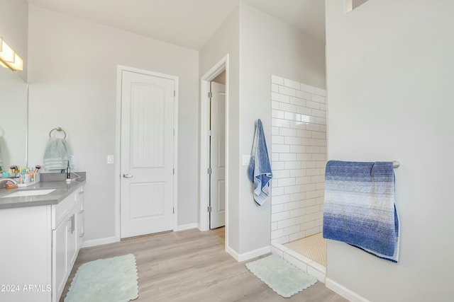 bathroom featuring hardwood / wood-style floors, vanity, and walk in shower