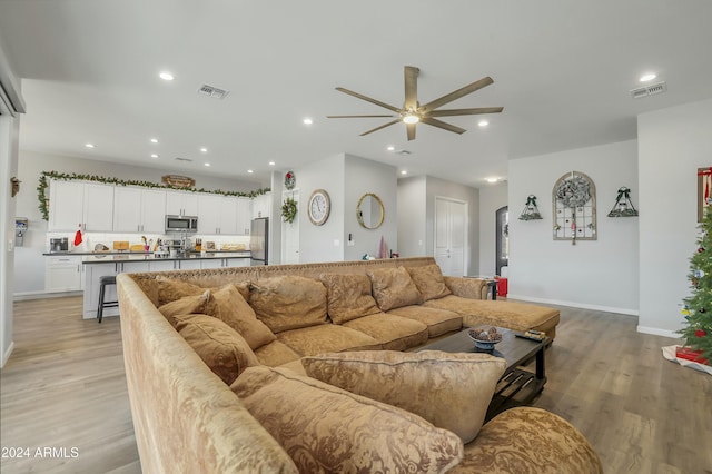 living room featuring light wood-type flooring and ceiling fan