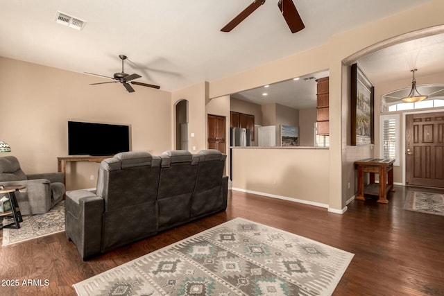 living room featuring dark wood-type flooring and ceiling fan