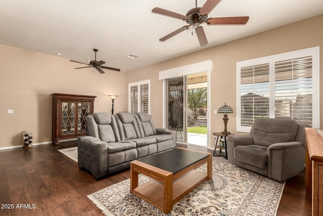 living room featuring ceiling fan and dark wood-type flooring