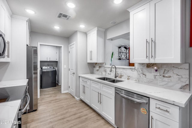 kitchen with stainless steel appliances, light hardwood / wood-style floors, white cabinetry, sink, and decorative backsplash