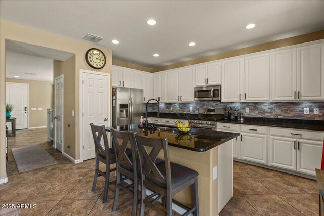 3936 E Narrowleaf Dr, Gilbert, AZ 85298 - kitchen with appliances with stainless steel finishes, backsplash, a sink, white cabinets, and a kitchen bar