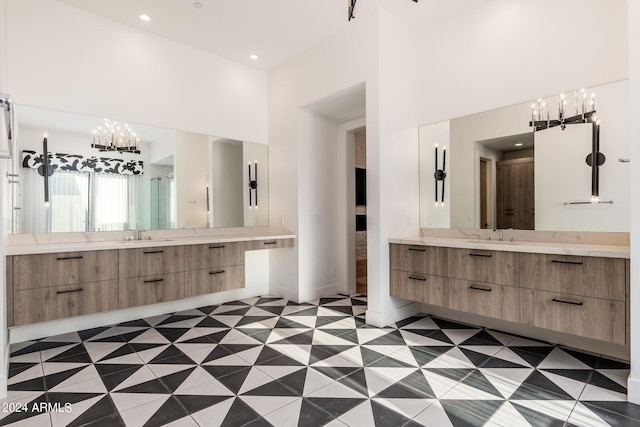 bathroom featuring a towering ceiling, a notable chandelier, and vanity