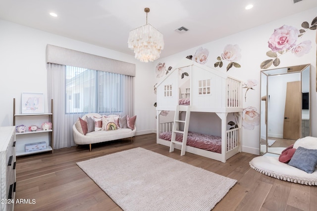 bedroom with hardwood / wood-style floors and a chandelier