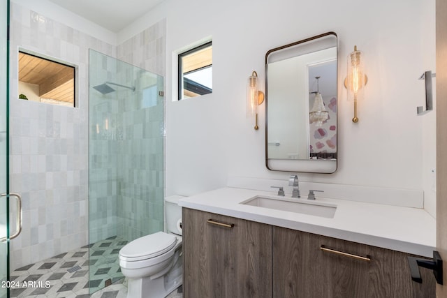 bathroom with a shower with door, vanity, and toilet