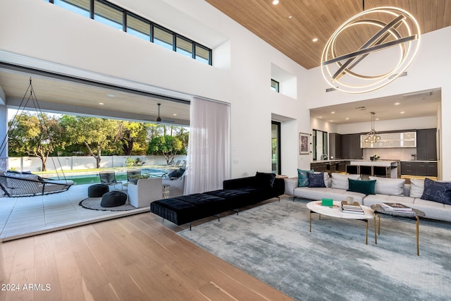 living room with a towering ceiling, wood-type flooring, and wooden ceiling