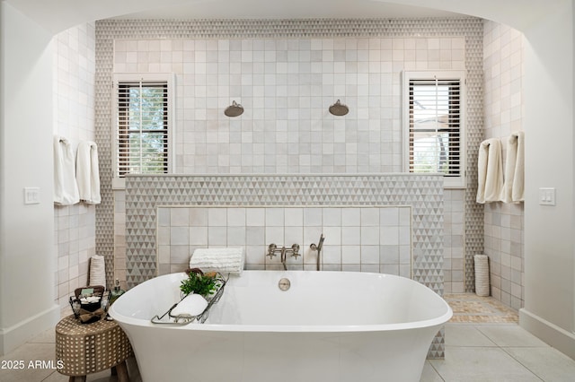 full bathroom with tile patterned flooring, a freestanding bath, tile walls, and walk in shower