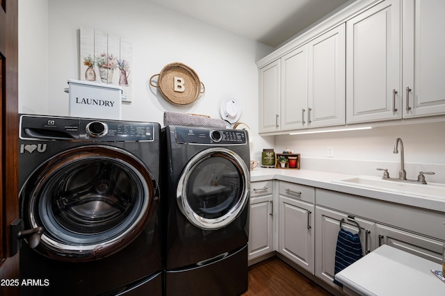 laundry room featuring cabinet space, dark wood-style floors, washing machine and dryer, and a sink