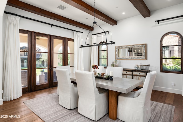 dining area featuring wood finished floors, visible vents, baseboards, beam ceiling, and french doors