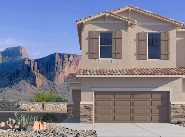 view of front of property with stone siding, stucco siding, a mountain view, and driveway