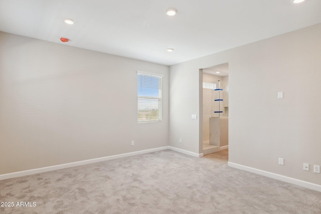 unfurnished room featuring recessed lighting, light colored carpet, and baseboards