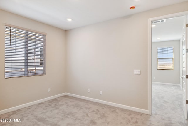 empty room featuring recessed lighting, baseboards, light carpet, and visible vents