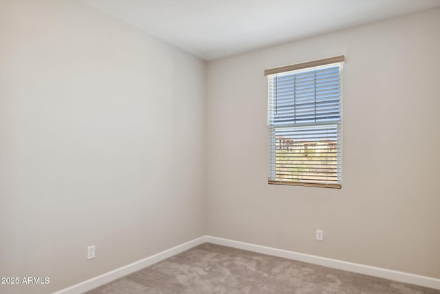 unfurnished room featuring baseboards and light carpet