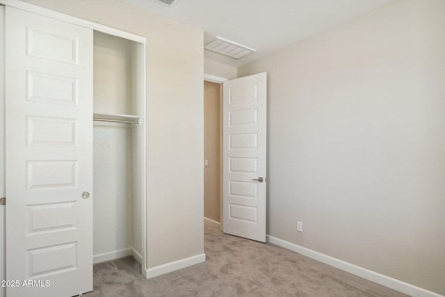 unfurnished bedroom with a closet, baseboards, carpet, and visible vents