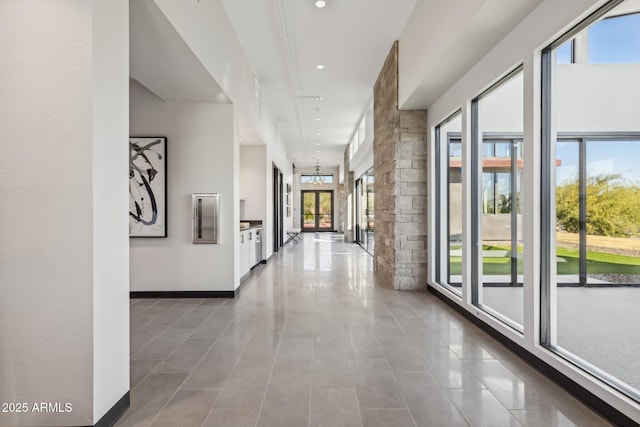 hall featuring tile patterned flooring, recessed lighting, and baseboards