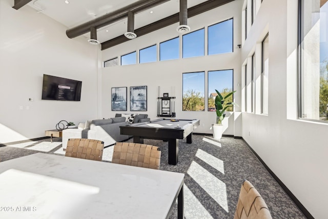 recreation room with beamed ceiling, baseboards, carpet floors, and a towering ceiling